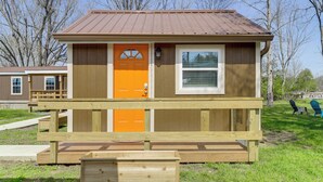 A small wooden building with a brown roof, a single orange door, and a window. - 2 Mi to Great Smoky Mtns NP! Cozy Cabin Retreat (Townsend)