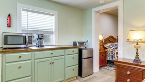 A kitchen with a microwave, toaster, and refrigerator. There is a window with blinds, a fire extinguisher, and a lamp on a dresser. - 2 Mi to Great Smoky Mtns NP! Cozy Cabin Retreat (Townsend)