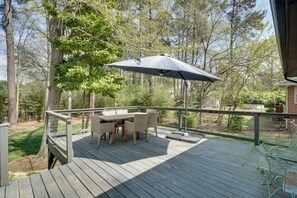 A wooden deck with a table and chairs, surrounded by trees. - Deck & Patio! Walkable Downtown Cary Home (Cary)