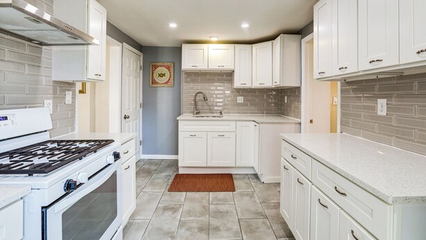 A modern kitchen with white cabinetry, a gas stove, and a tiled backsplash. - 1 Mi to NYC Train & Arts District: Rahway Escape (Rahway)