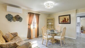 A dining area with a glass table, four chairs, a decorative wall shelf, and a window with curtains. - 1 Mi to NYC Train & Arts District: Rahway Escape (Rahway)