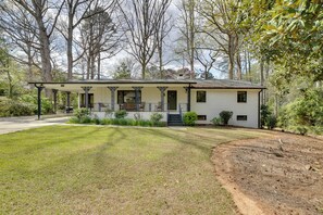 A single-story house with a covered porch, a front yard, and a driveway. - Quiet Downtown Cary Home w/ Screened Porch (Cary)