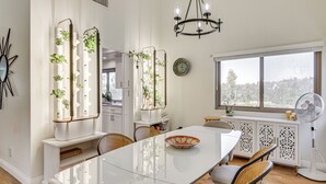 A modern kitchen with a dining table, chairs, a chandelier, and a view through a window. - Hot Tub, Pool & Socal Sunsets: San Diego Area Home (Spring Valley)