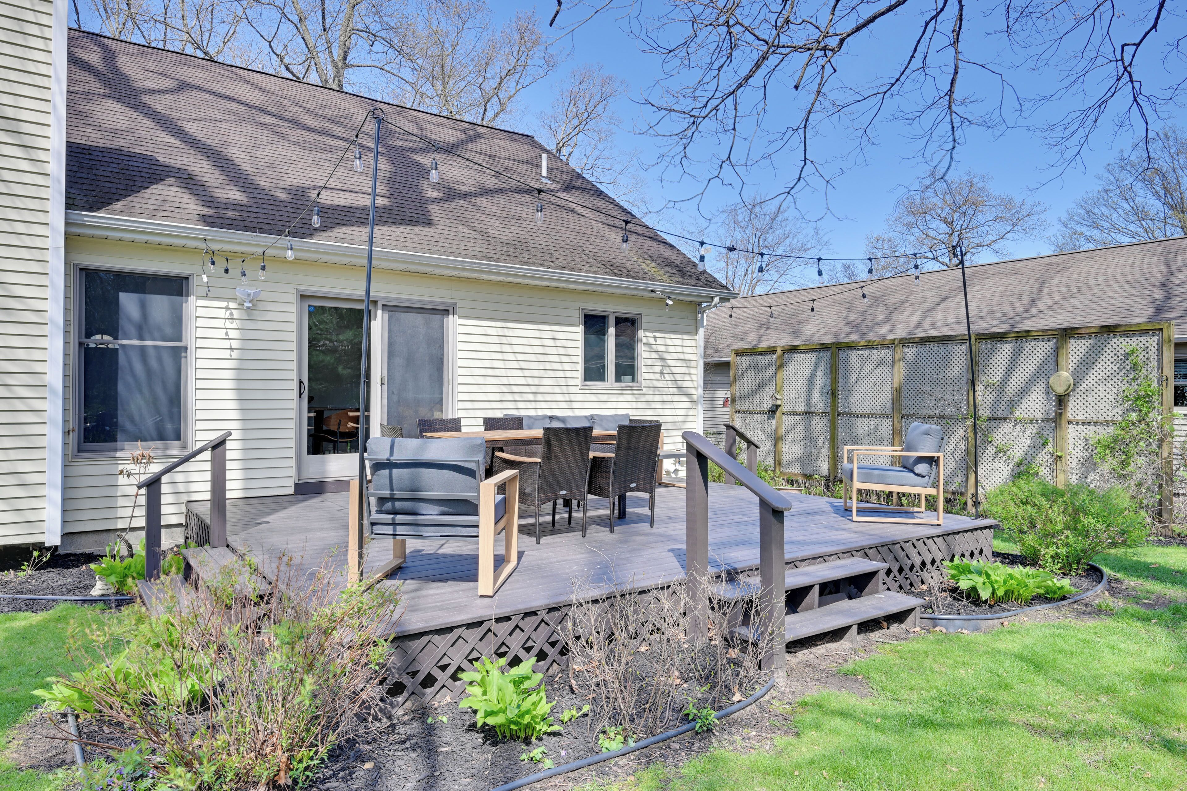 Een huis met een terras, tuinmeubilair en een tuin.