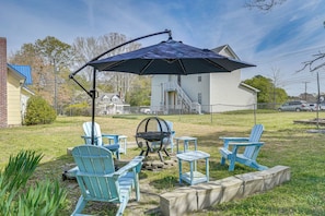 A backyard with outdoor furniture, a fire pit, and a large umbrella. - Half-mi to Dtwn Wendell! 60s Farmhouse w/ Fire Pit (Wendell)