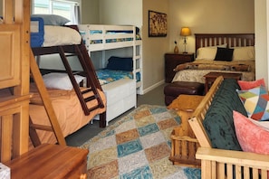 A room with bunk beds, a desk, a chair, a patterned rug, and a nightstand with a lamp. - 'stargazer's Delight' in the Ozarks: Country Cabin (Richland)