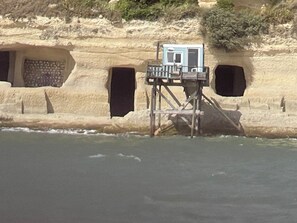 A coastal structure with a small building on stilts, two openings in the rock, and a wooden railing. - Comfortable gîte for 4 people with swimming pool, large garden - 15 km from the sea (Chenac-Saint-Seurin-d'Uzet)