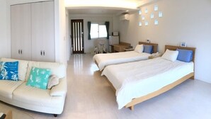 A hotel room with two beds, a sofa, a desk, and a wardrobe. - Island Village Ishigaki-jima (Ishigaki)