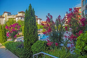 Una piscina al aire libre de temporada, sombrillas