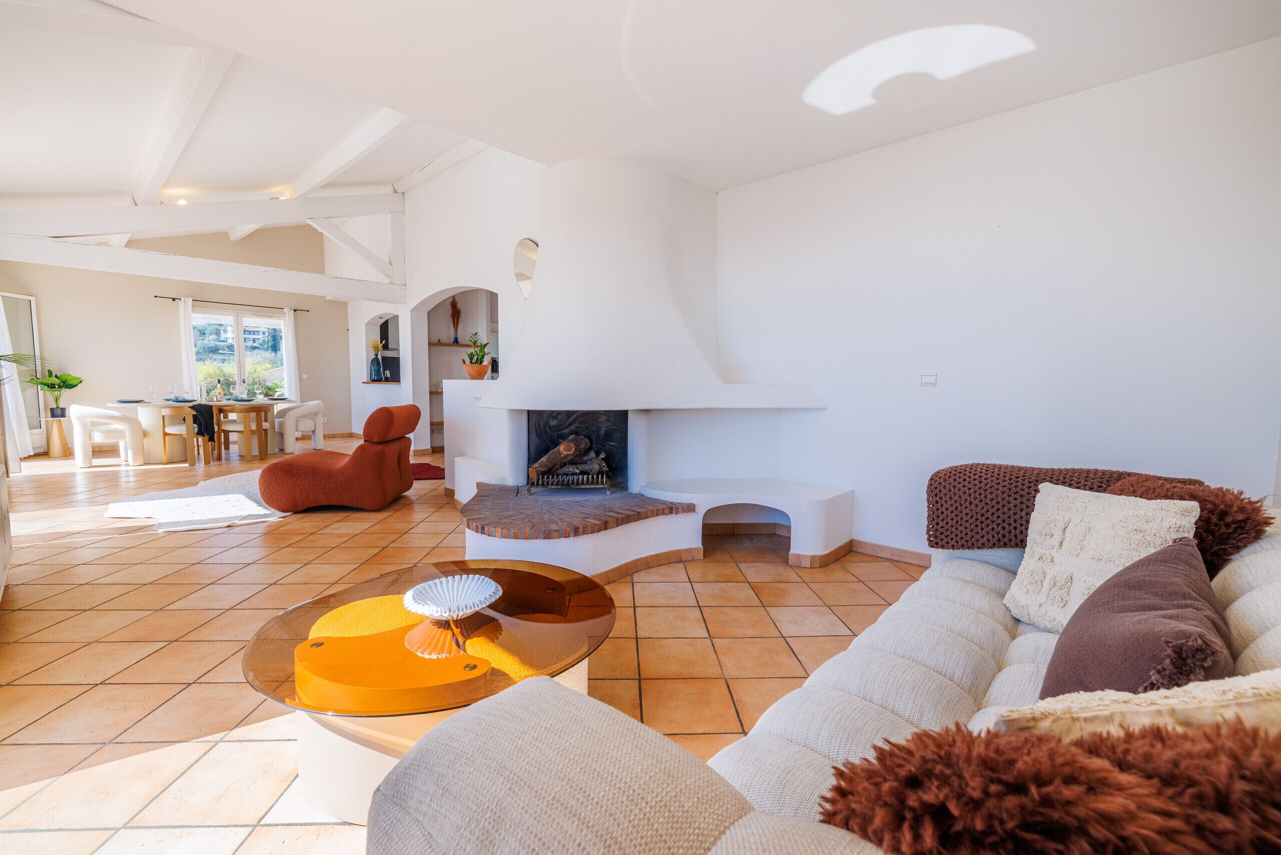 A spacious living area with a fireplace, a dining area, and a view of the outdoors.