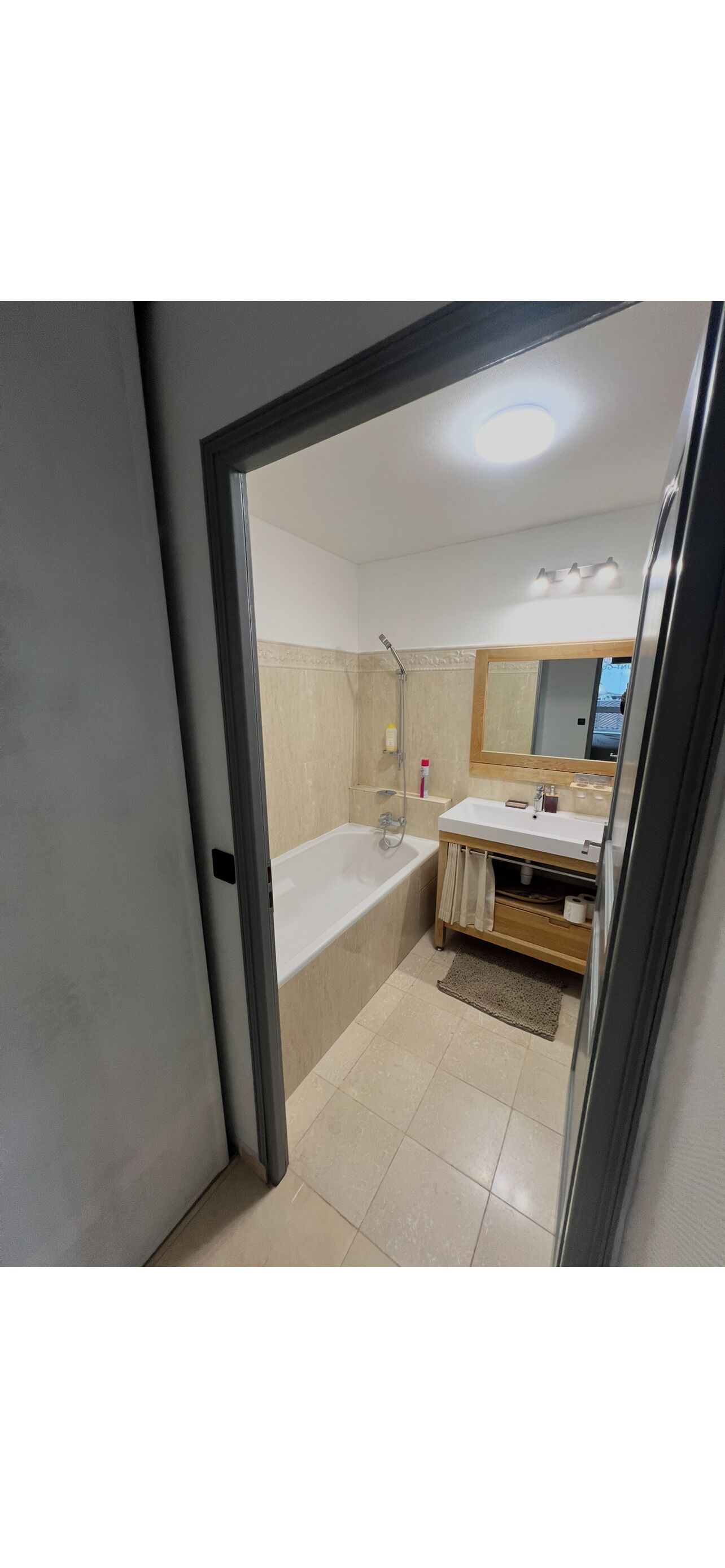 A bathroom with a bathtub, a sink, a mirror, and a shower.