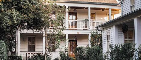 A two-story house with a porch, a staircase, and a number '70' on the front.