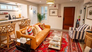 A living room with a sofa, armchairs, a coffee table, and a patterned rug. - Charleston Charm: Cozy 1BR Apartment with Patio (Charleston)