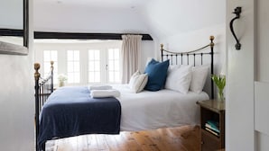 Une chambre à coucher avec un lit, une table de chevet, une fenêtre et une vue sur l’extérieur.
