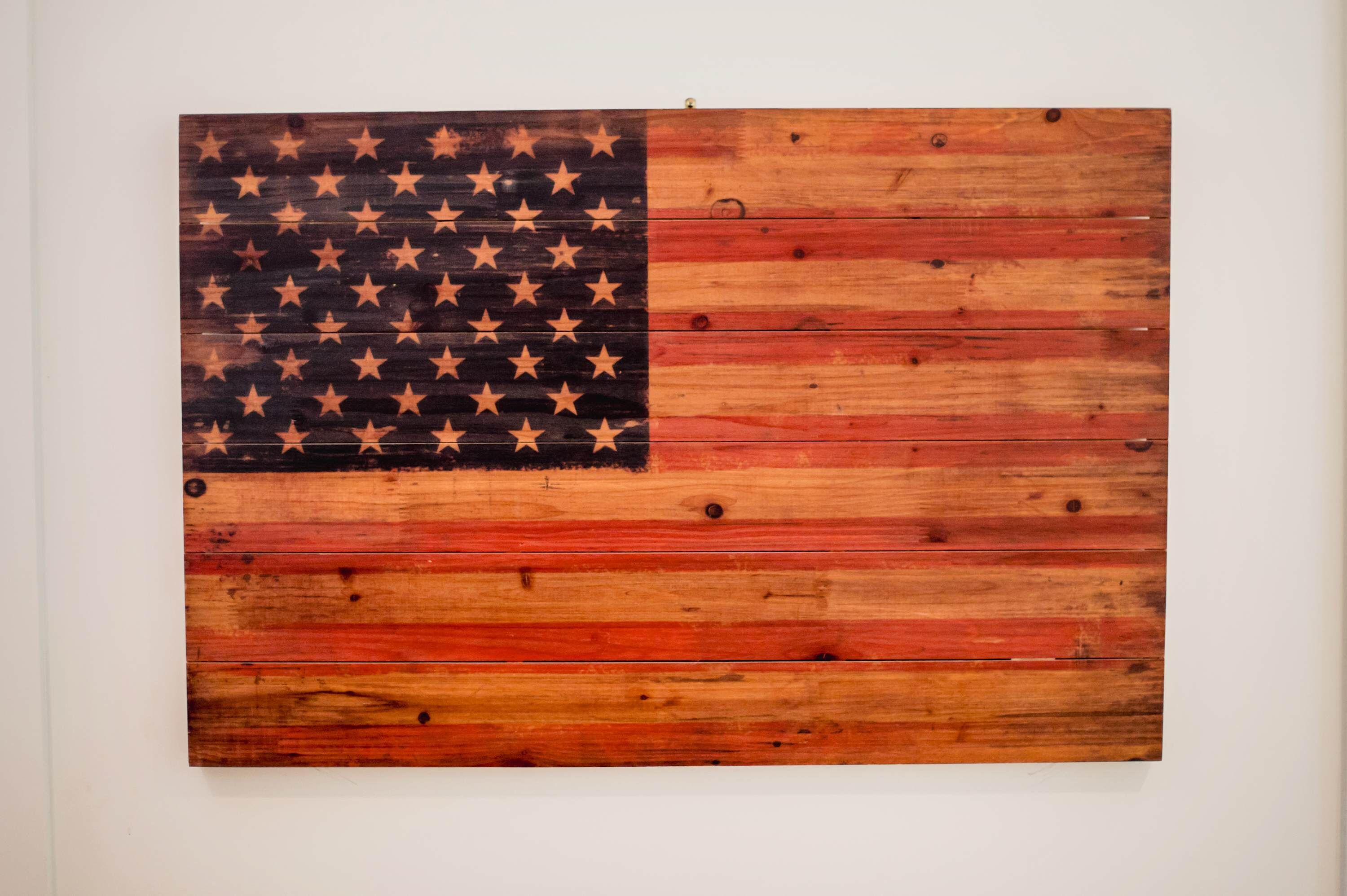 A wooden wall with a painted American flag.