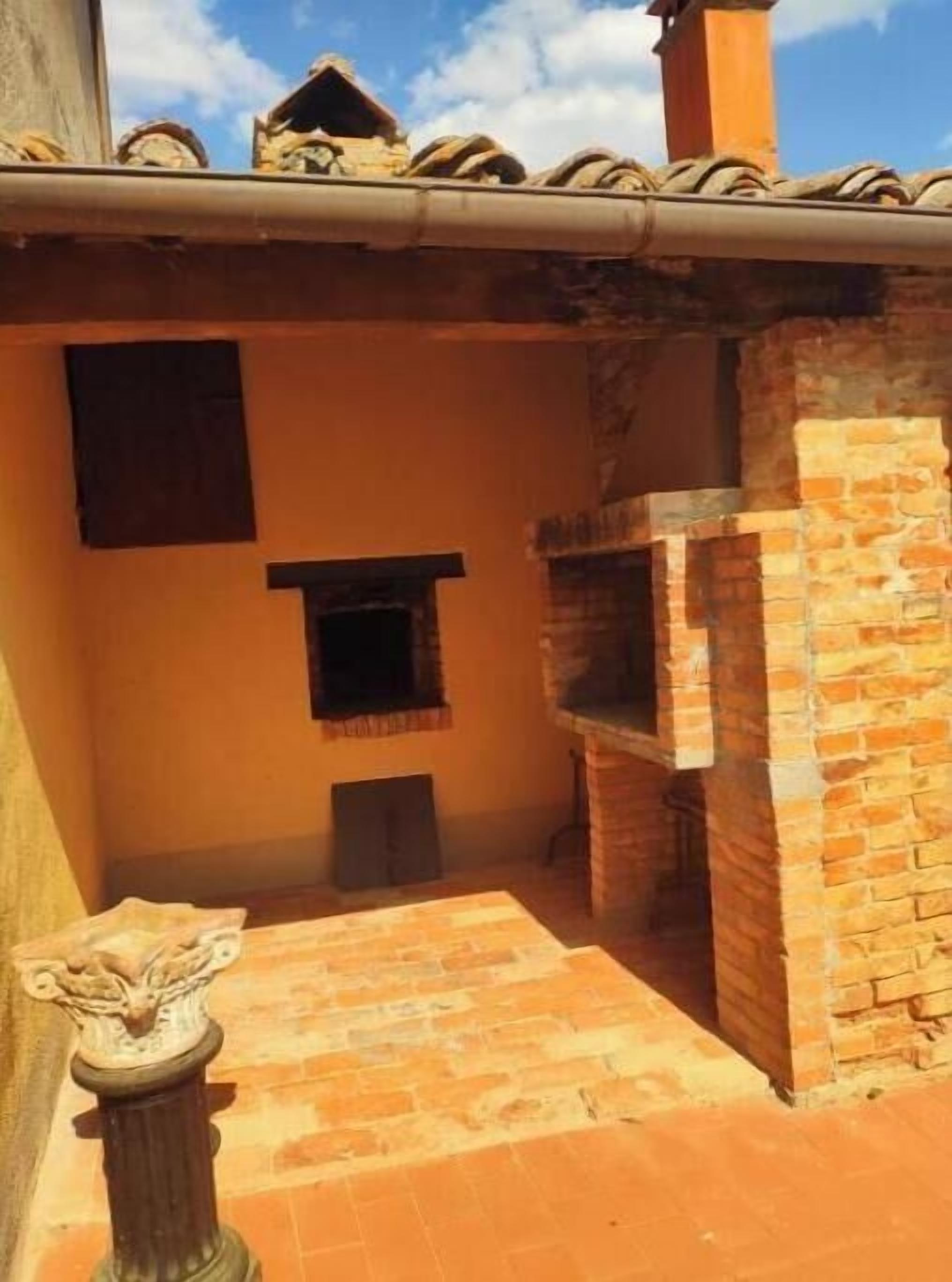 Ein Innenhof mit Backofen, kleinem Fenster und Statue.