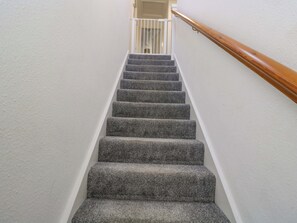 A carpeted staircase with a wooden handrail and white walls. - 3 Woods Farm House (Chippenham)