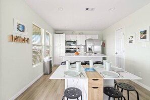 A modern kitchen with white cabinets, stainless steel appliances, and a central island with seating.
