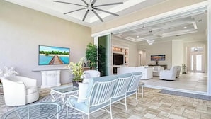 A spacious living area with a TV, seating, and a view of the interior. - Luxury Naples Retreat / Pool, Near Beach (Naples)