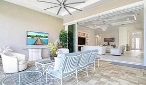 A spacious living area with a TV, seating, and a view of the interior. - Luxury Naples Retreat / Pool, Near Beach (Naples)