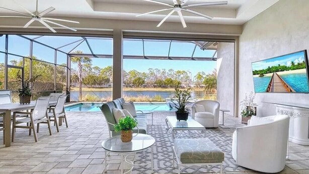 A spacious indoor area with a pool, seating, and a large TV screen. - Luxury Naples Retreat / Pool, Near Beach (Naples)