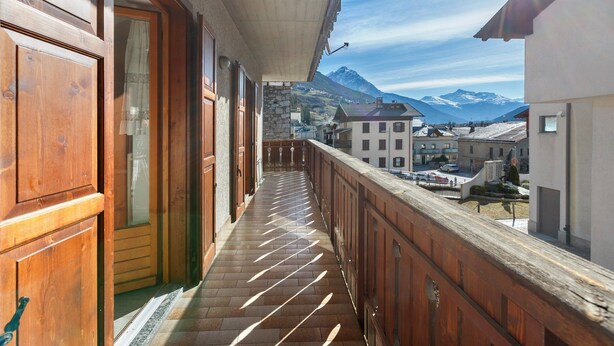 A balcony with a view of mountains and a town.