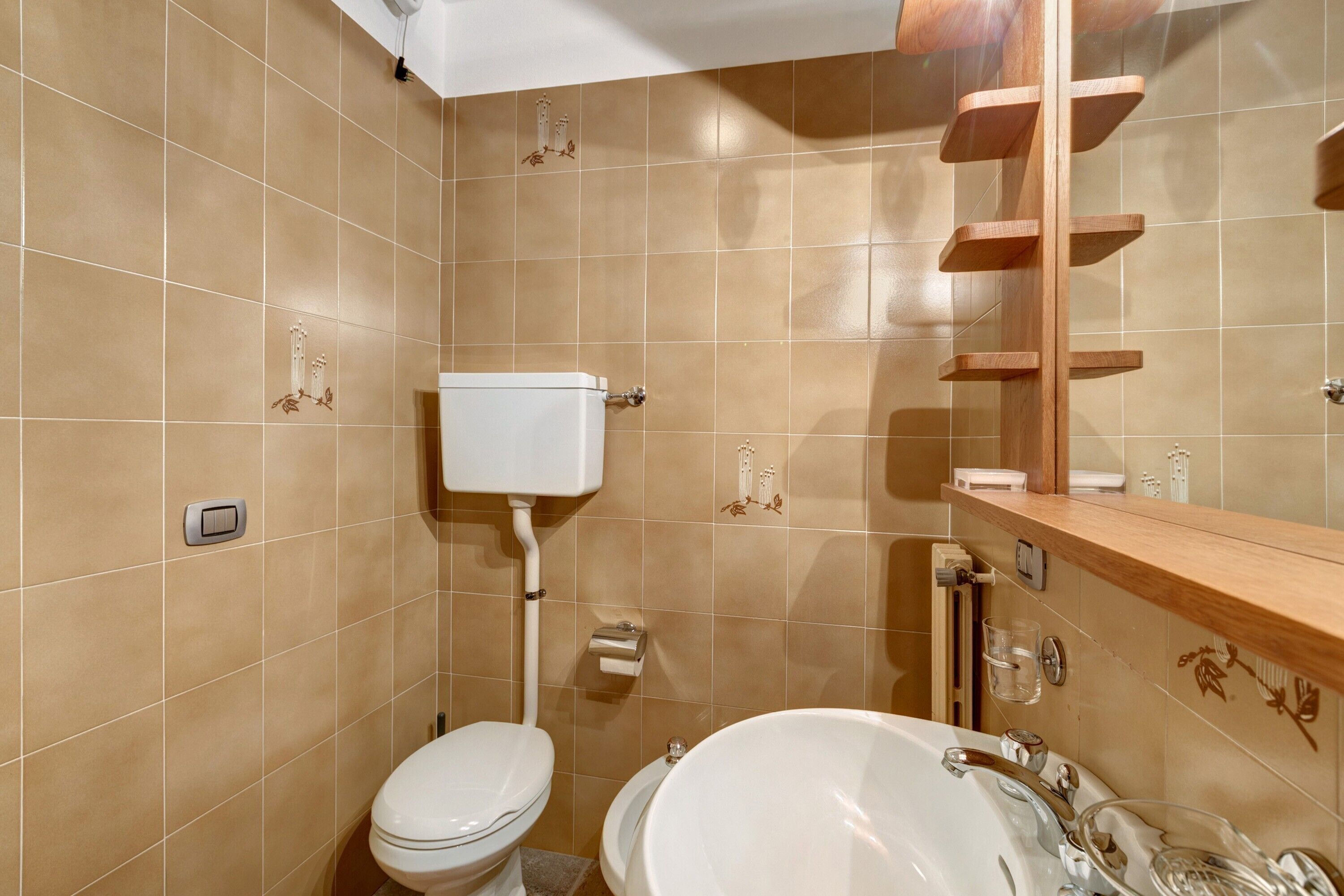 Ein Badezimmer mit Toilette, Waschbecken und Spiegel.