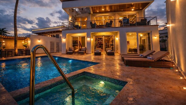 Ein zweistöckiges Gebäude mit Pool, Außenbereich und einer Treppe, die zu der oberen Etage führt.