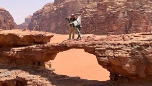 Paisaje desértico con formaciones rocosas y un arco natural.