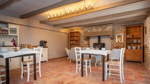 A rustic kitchen with a stone wall, wooden cabinets, and a tiled floor. - Guesthouse “Lorient Room” with Terrace and Shared Garden (Guilligomarc'h)