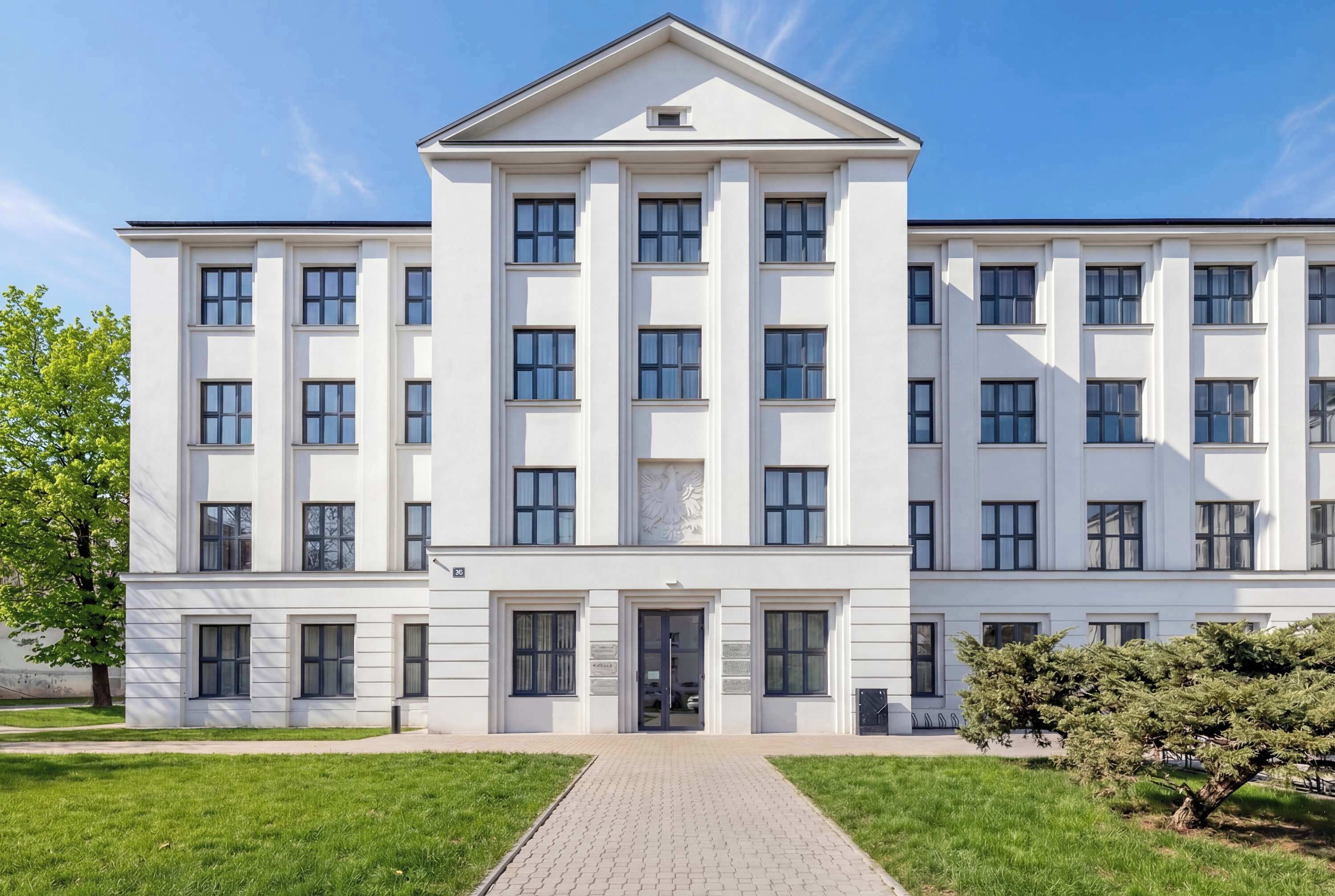 Un immeuble à plusieurs étages doté d’une façade symétrique, de grandes fenêtres et d’une entrée centrale.