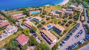An aerial view of a coastal residential area with houses, a swimming pool, and a beach. - FRUIT VILLAGE BAIA DELLA ROCCHETTA (Briatico)