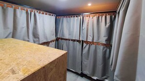 Een kamer met een houten bureau, een plafondlamp en gordijnen voor de ramen.