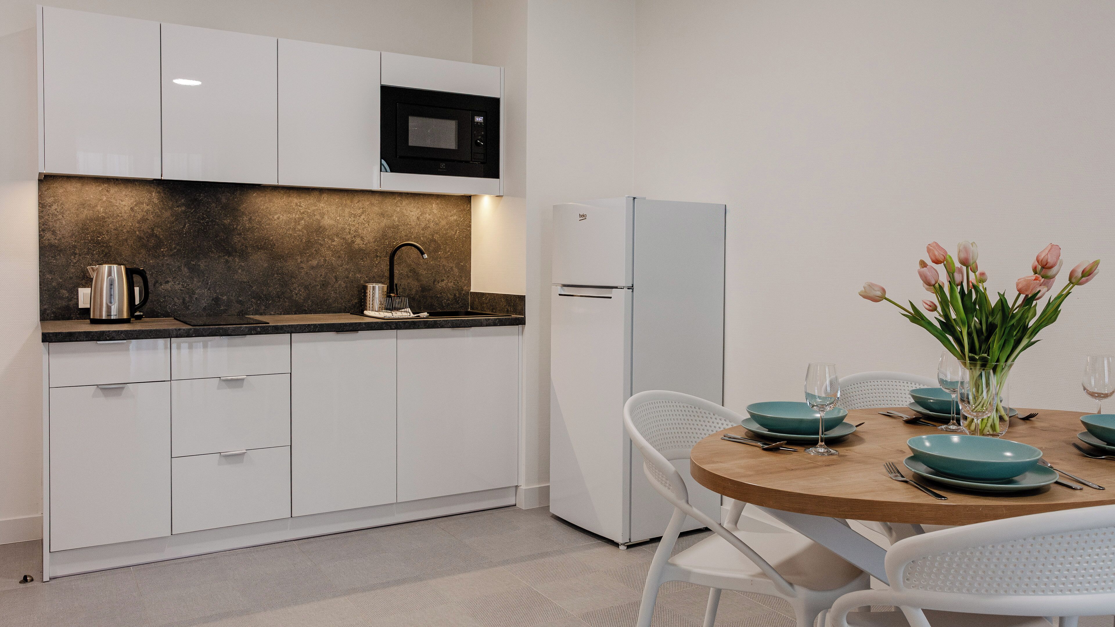 Appartement (78) | Privékeuken | Een koelkast, een kookplaat, een waterkoker, kookgerei, borden en bestek
