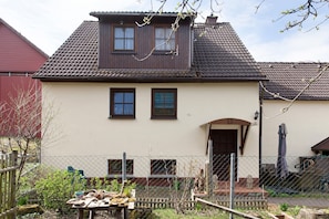 A two-story house with a tiled roof, a front door, and a small porch. - Apartment “Linke Hof” with Wi-Fi (Bobritzsch-Hilbersdorf)