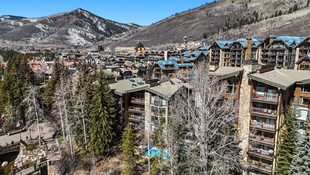 A mountain resort town with multi-story buildings, a ski lift, and a clear view of the surrounding mountains. - Cozy Mountain Getaway by InvitedHome | Walk to Ski, Hot Tub, Village Center (Vail)