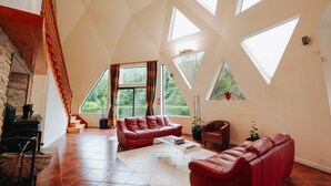 Un loft espacioso con techo alto, ventanas grandes y una escalera.