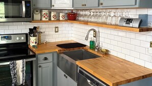 A kitchen with grey cabinets, a microwave, a stove, a sink, and a dishwasher. - Historic home in downtown Richmond by the James River (Richmond)