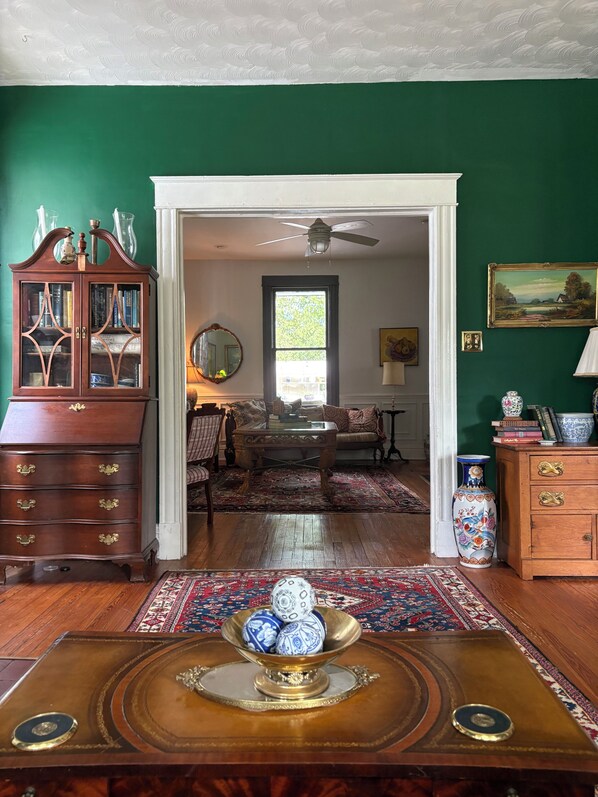Una habitación con un armario de madera, un espejo, un sofá y un tapete estampado.