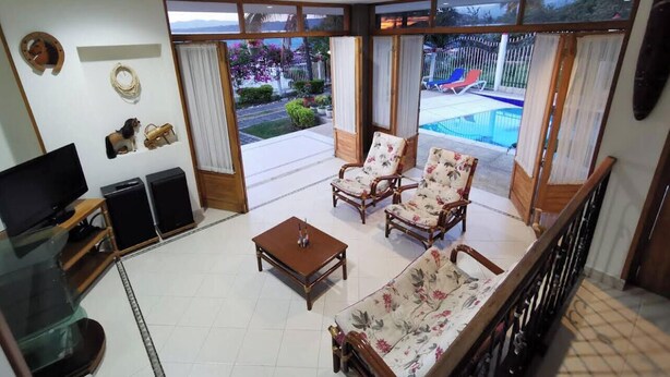 A living room with a sofa, two armchairs, a coffee table, a TV, and speakers. - VILLA LUZ house for rent in Mesitas del Colegio (El Colegio)