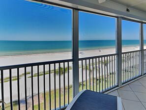 Ein Balkon mit Blick auf Strand und Meer.