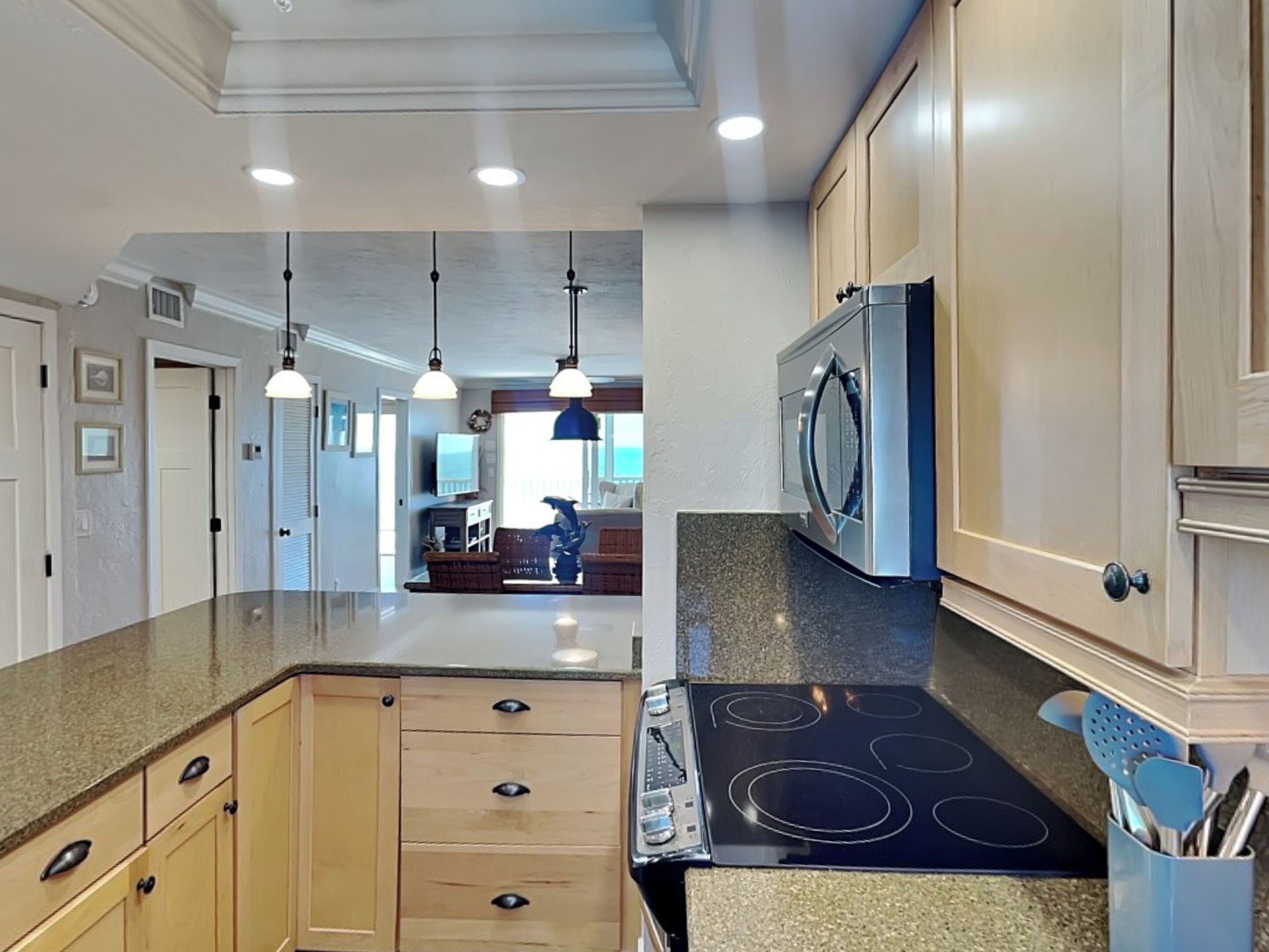 A kitchen with a central island, built-in oven, and granite countertops.