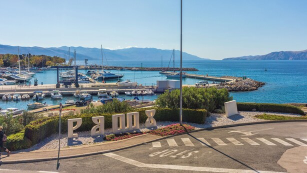 A marina with boats docked, a clear sky, and mountains in the background. - Vacation apartment close to the beach with private parking and barbecue (Novi Vinodolski)