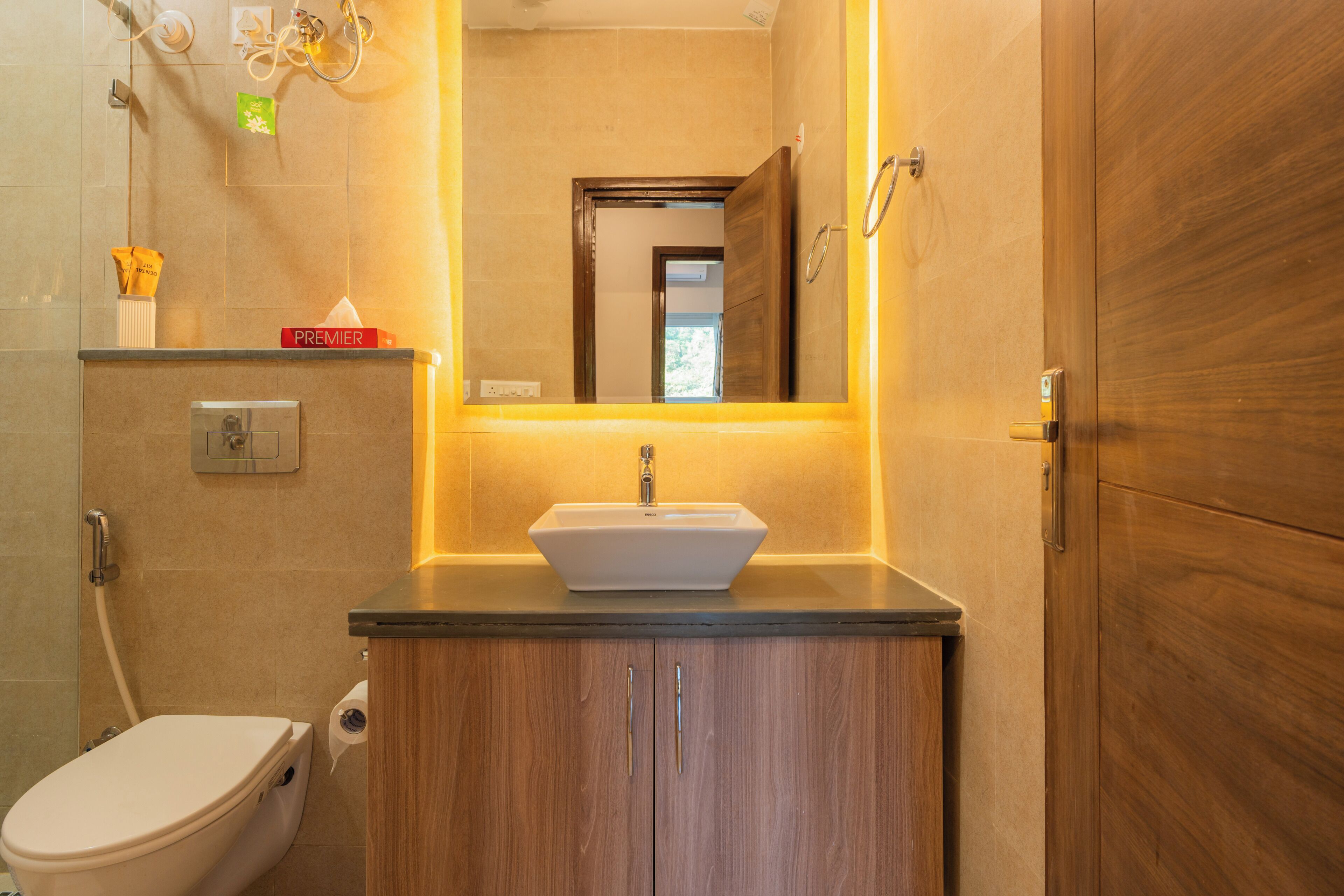 Un bagno con un lavandino bianco, mobili in legno, un water e uno specchio.