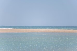 Een strand met helder water en een zandkust.
