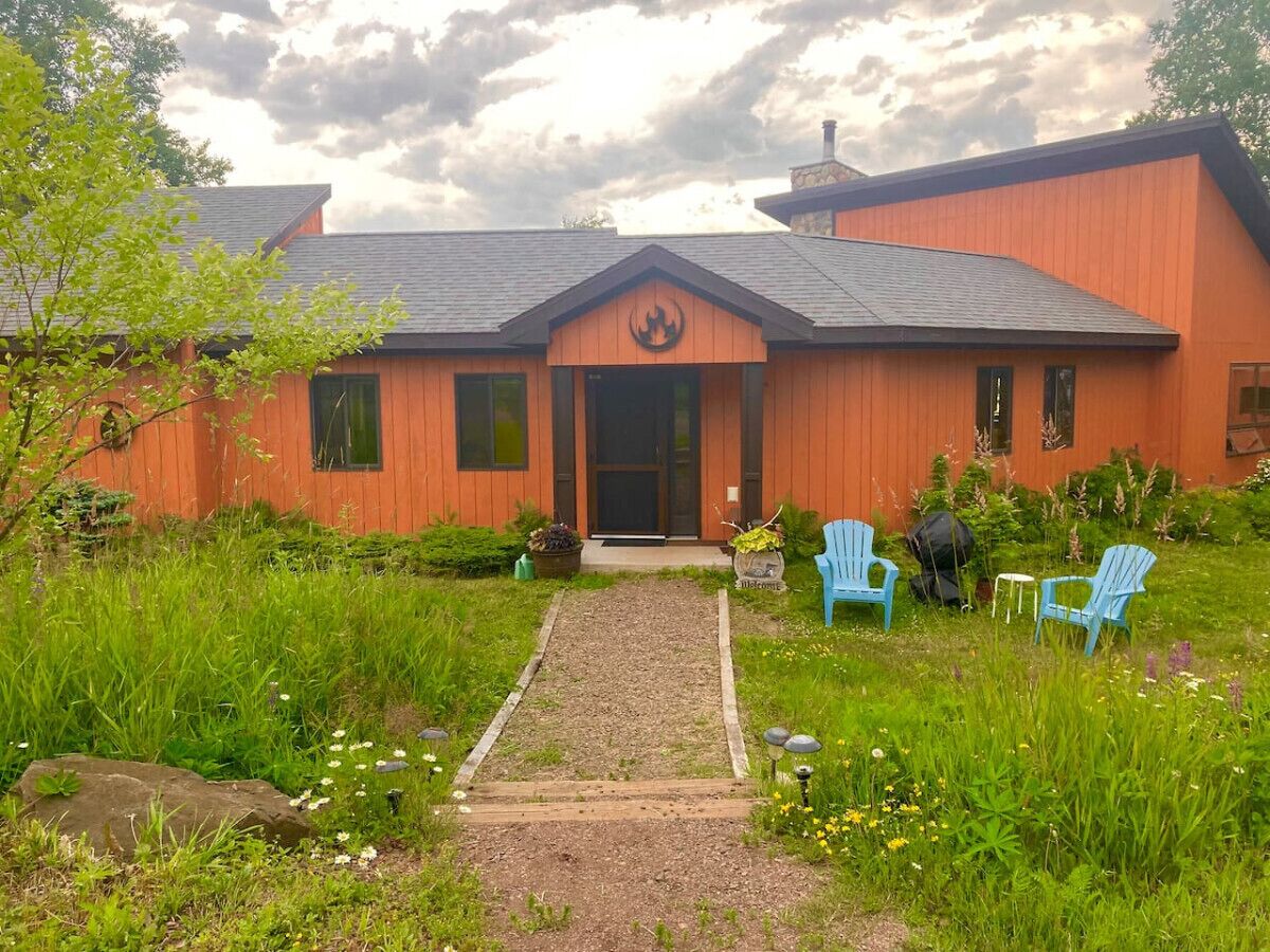 A building with a prominent logo, a gravel pathway, and outdoor seating.