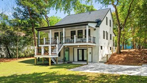 Een woonhuis met twee verdiepingen, een overdekte veranda, een trap en een voordeur.