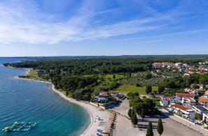 Eine Küstenstadt mit Strand, Wohnhäusern und blauem Himmel.