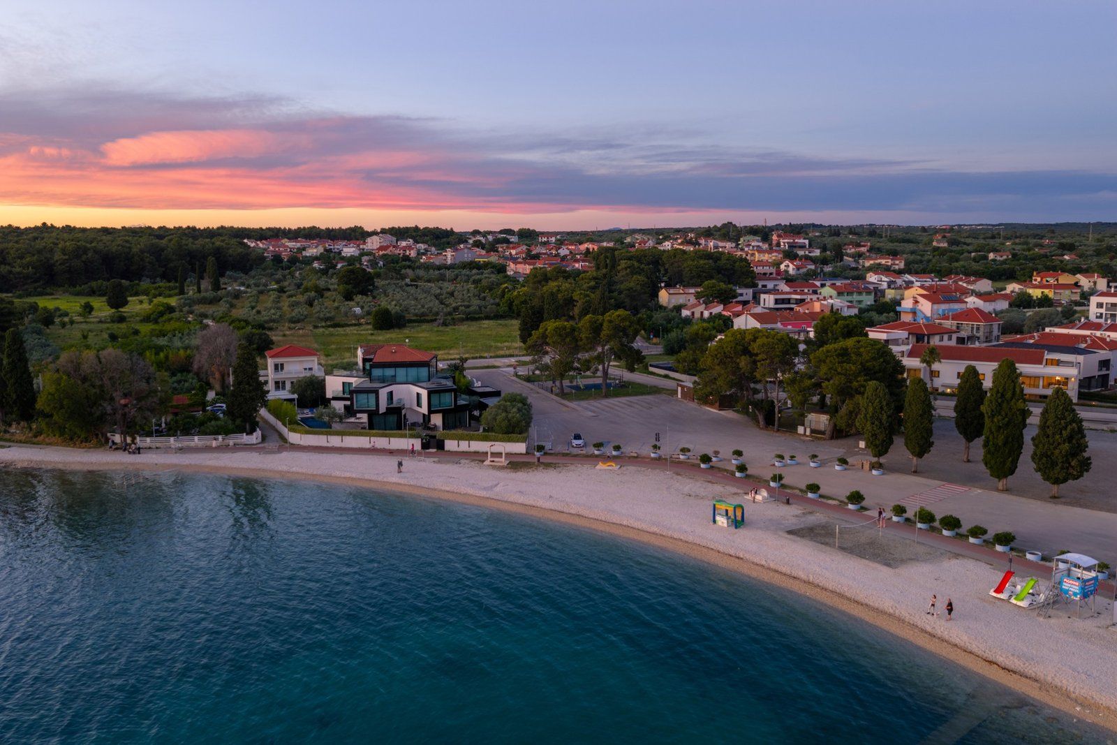 Une ville côtière dotée d’une plage, d’immeubles modernes et offrant une vue dégagée sur la mer.
