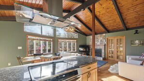 A spacious kitchen with a large island, a dining area, and a living room with a fireplace.